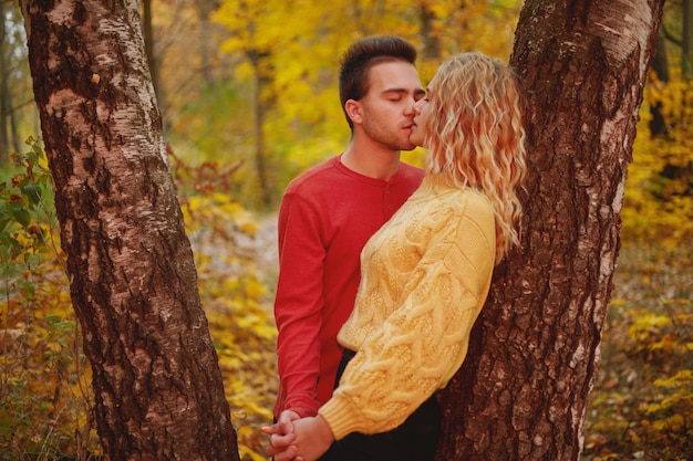 Happy young couple outdoors on a beautiful autumn day in the forest