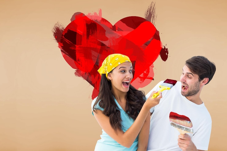 फोटो happy young couple painting together and laughing against room with wooden floor