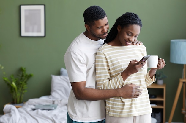 Happy young couple reading message on smartphone