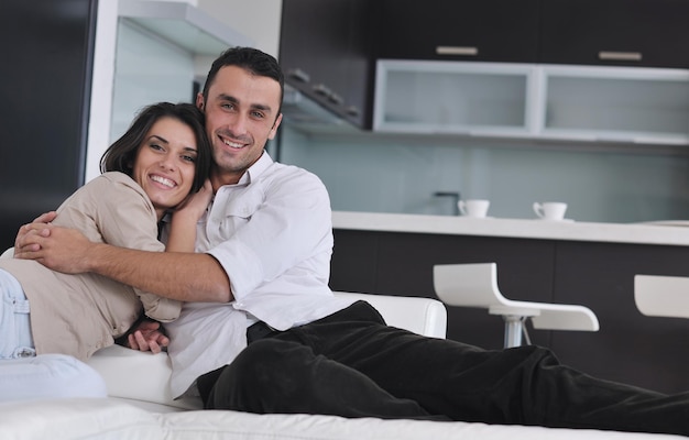 행복한 젊은 커플은 현대적인 가정 거실에서 휴식을 취합니다.