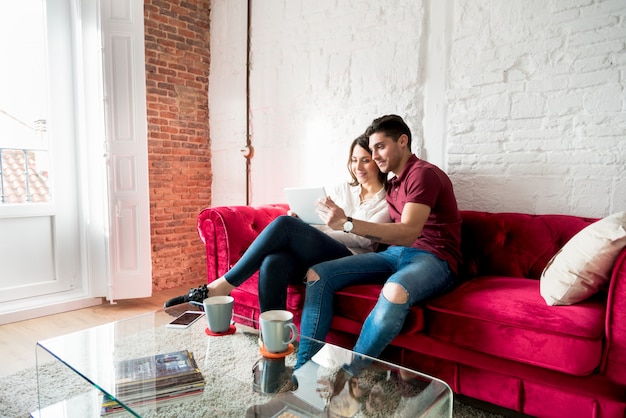 Happy young couple relaxed at home with a tabet