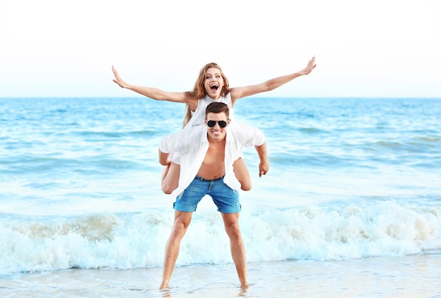 Foto giovani coppie felici sulla spiaggia del mare