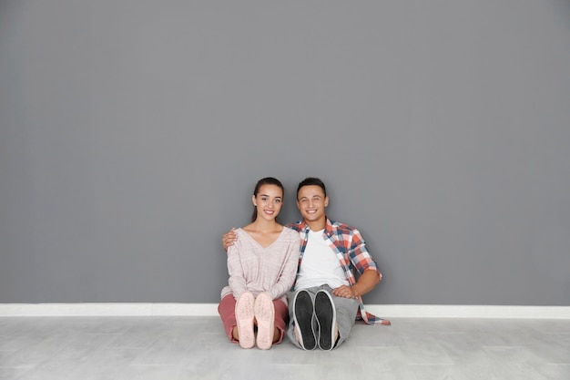 Happy young couple sitting on floor in their new apartment House move concept