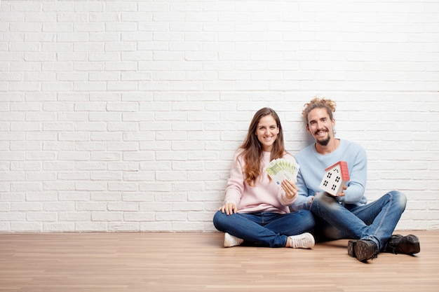 Happy young couple sitting on the floor of their new house. conc