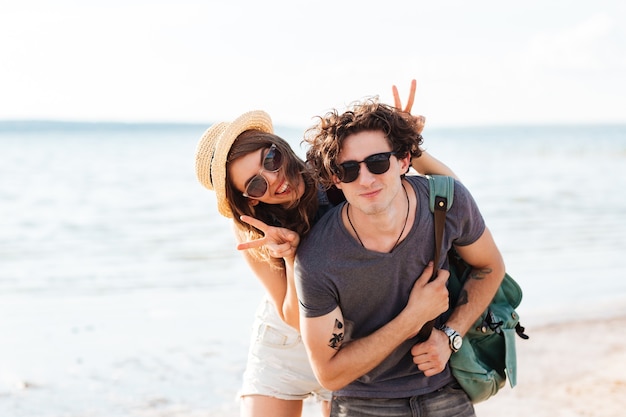 Giovani coppie felici che sorridono e che si divertono insieme sulla spiaggia