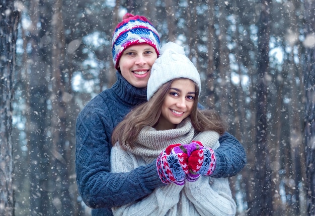 Happy young couple under the snow in winter.