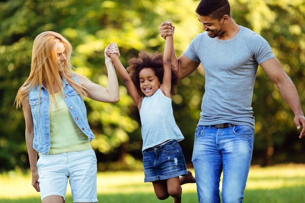 Happy young couple spending time with their daughter in nature