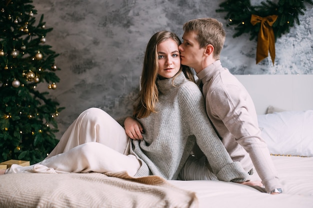 Happy young couple staying in bed at home