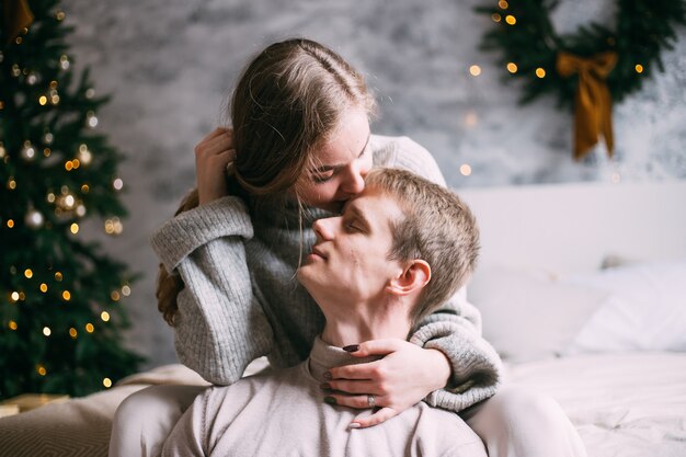 Happy young couple staying in bed at home