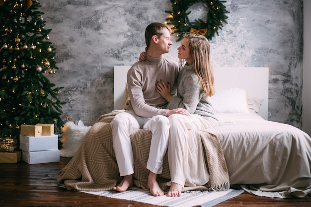 Happy young couple staying in bed at home