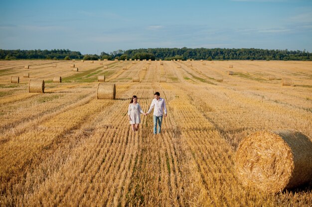 Happy young couple on straw, romantic people , beautiful landscape, summer season