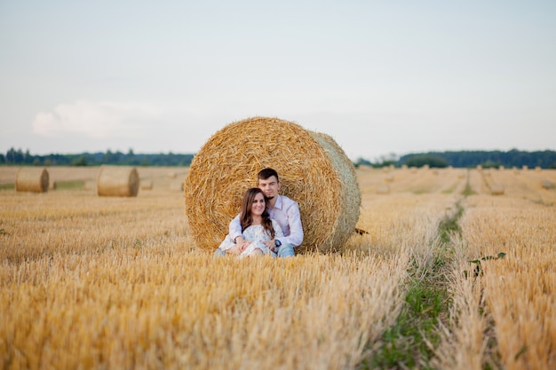 Giovani coppie felici su paglia, concetto romantico della gente, bello paesaggio, stagione estiva