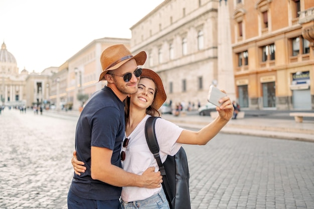 Photo happy young couple taking selfie portrait with smartphone mobile outdoor tourism friendship