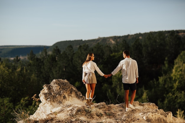 Happy young couple traveler in casual outfits on pine forest background