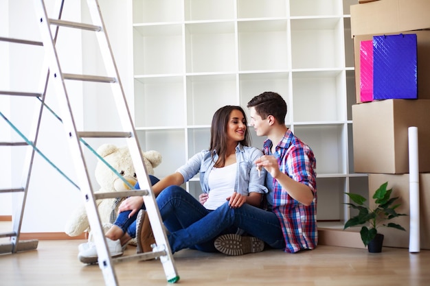 Photo happy young couple unpacking or packing boxes and moving into a new home.