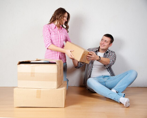 Happy young couple unpacking or packing boxes and moving into a new home.