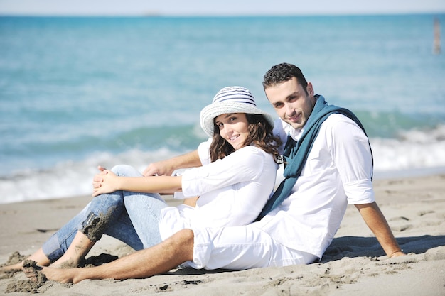 Foto le giovani coppie felici in abiti bianchi hanno una ricreazione romantica e si divertono sulla bellissima spiaggia in vacanza