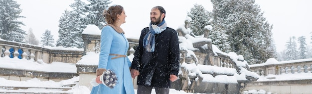 Photo happy young couple in winter park family outdoors at the castle