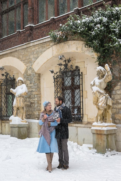 Счастливая молодая пара в зимнем парке Семья на открытом воздухе в замке