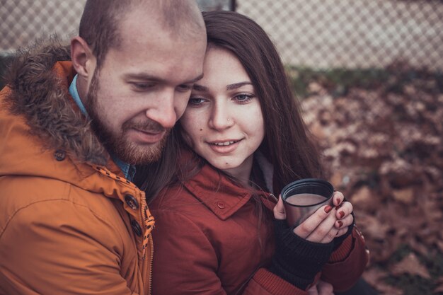 Photo happy young couple in winter park having fun. family outdoors.