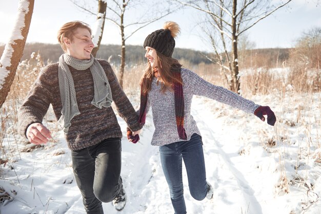 Happy Young Couple in Winter Park having fun.Family Outdoors