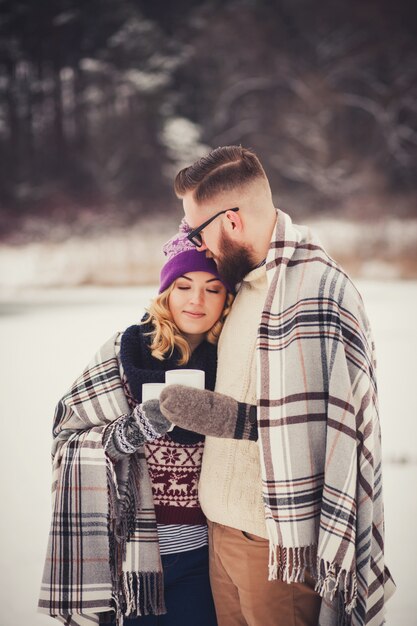 Photo happy young couple in winter park