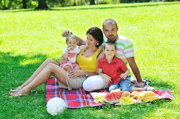 Фото Счастливая молодая пара со своими детьми развлекается в красивом парке на природе