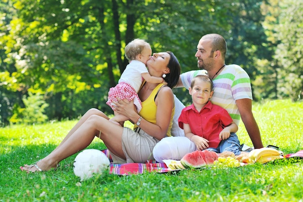 happy young couple with their children have fun at beautiful park outdoor in nature