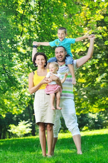 Felice giovane coppia con i loro figli si divertono al bellissimo parco all'aperto nella natura