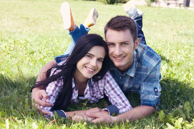 Happy young couple with white perfect smile in summer clothing on a walk in the park