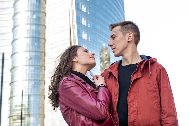 Happy young couples flirting high skyscrapers and modern skyline on background love concept of the millenials generation copy space