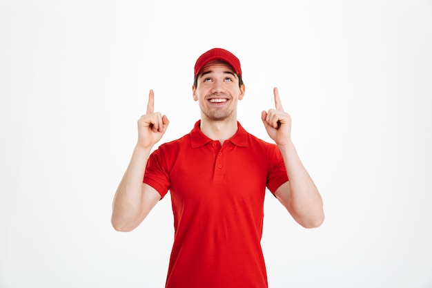 Photo happy young delivery man pointing isolated