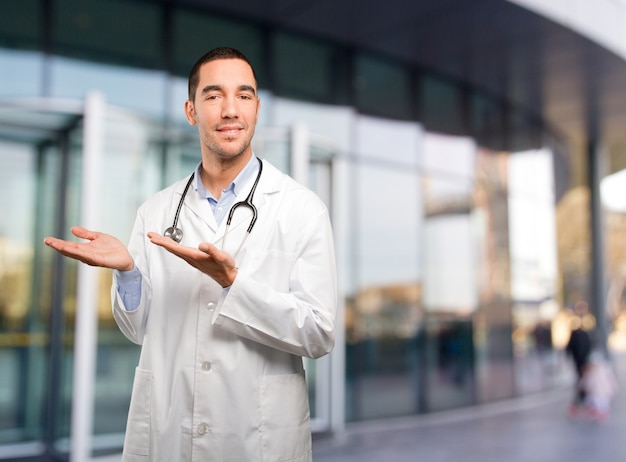 Happy young doctor doing a show gesture