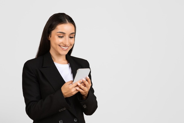 スマートフォンを使う幸せな若いヨーロッパのビジネスウーマン