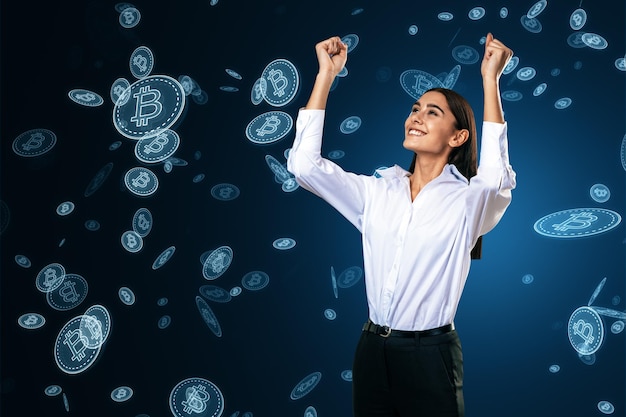 Happy young european female with falling digital bitcoins on blue background Success cryptocurrency exchange and money concept