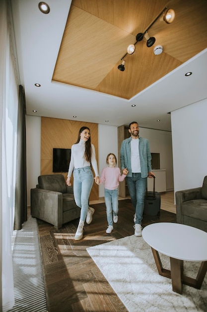 Happy young family arrive into hotel room