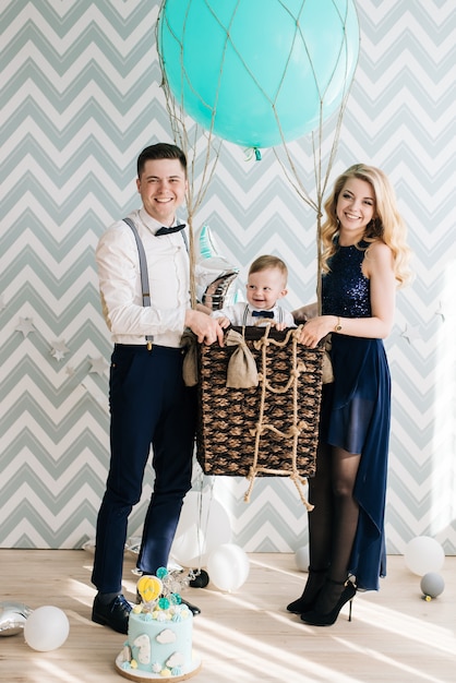 Happy young family celebrates the first birthday of the child.