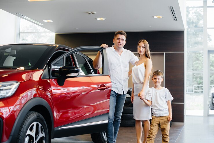 A happy young family chooses and buys a new car at a car dealership. Buying a new car.