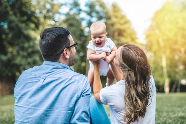 Happy young family enjoying together in park.