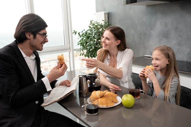 La giovane famiglia felice fa colazione a casa