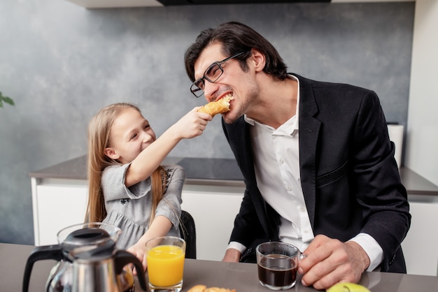 幸せな若い家族は家で朝食をとる