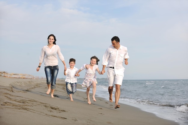 счастливая молодая семья веселится и ведет здоровый образ жизни на пляже