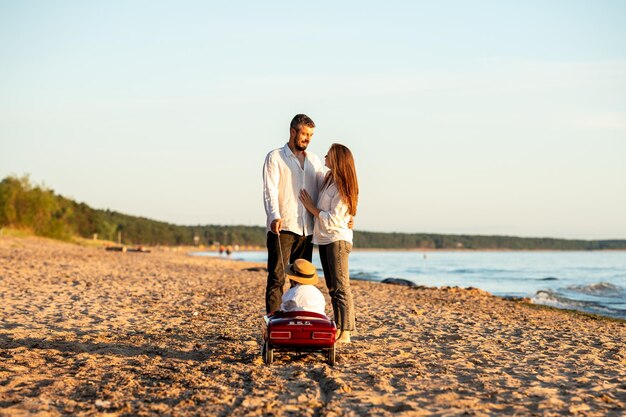 写真 幸せな若い家族が海辺で楽しんでいます母と父と娘は休暇中です