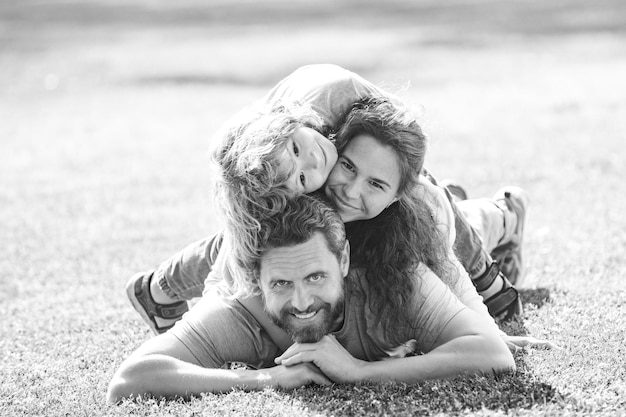 Happy young family hugging and embracing together outside in green nature