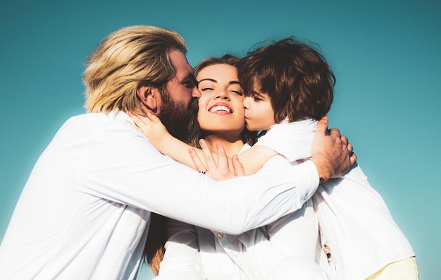 Happy young family in love kissing outdoors