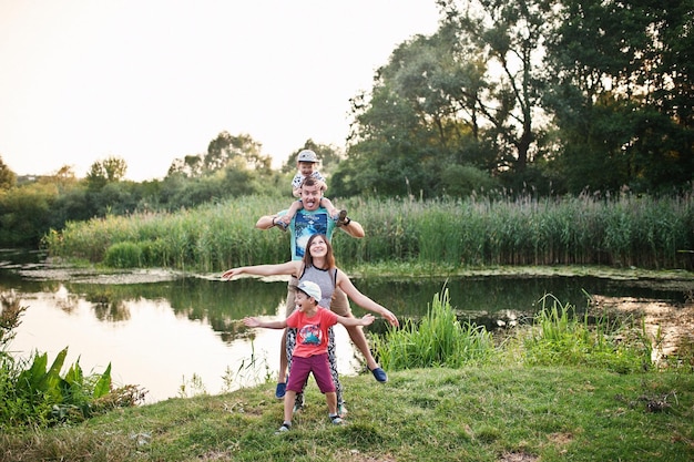 Happy young family mother father two children son on nature having fun