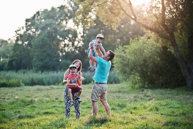 Happy young family mother father two children son on nature having fun