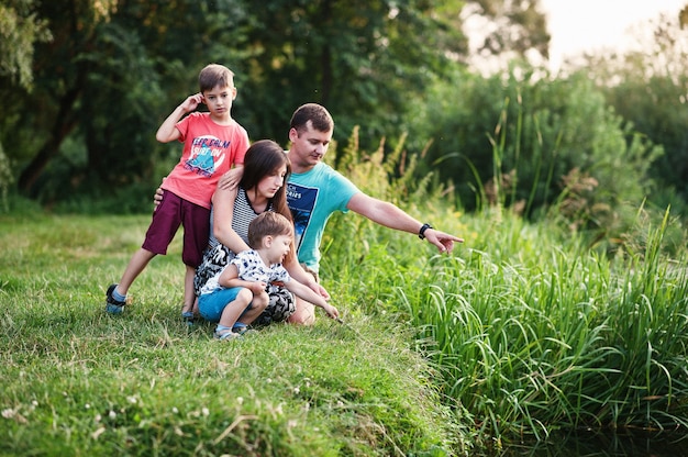 행복한 젊은 가족:어머니, 아버지, 자연에서 두 아이의 아들이 즐겁게 놀고 있습니다.