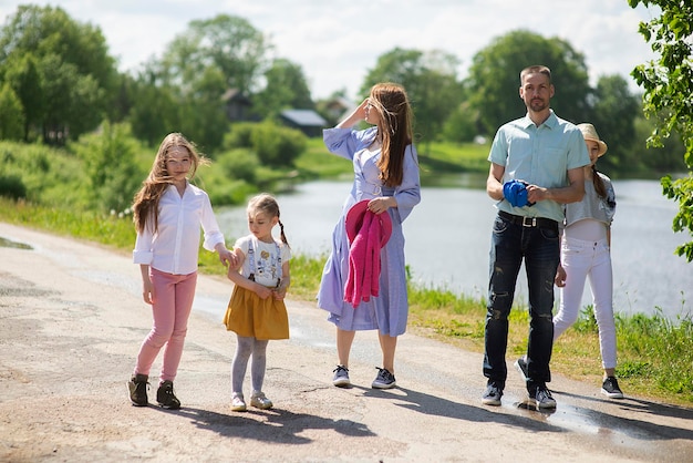 Photo happy young family motherfather and three children daughter girls walking on city sidewalk