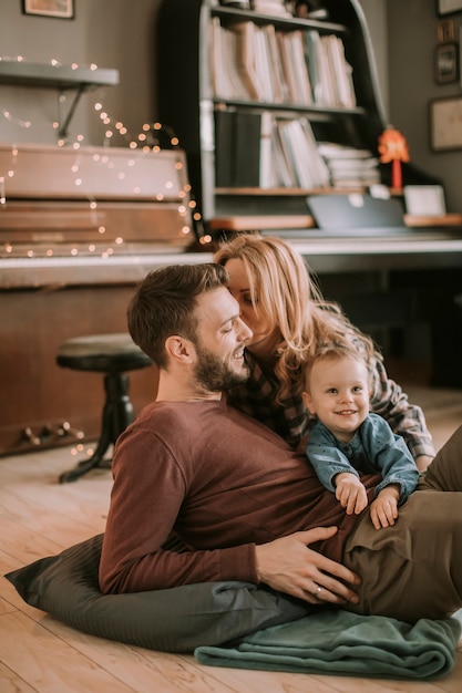 Happy young family playing on the floor  in the room